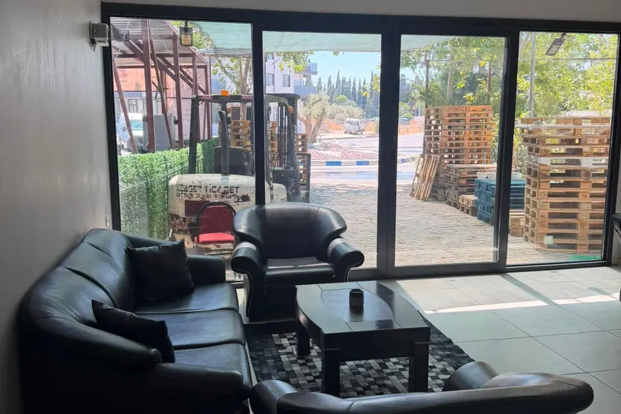 Dükkanın içindeki oturma ve görüşme alanı, camdan bahçedeki forklift görünüyor
