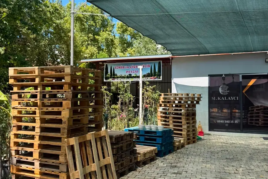 İzmir Pınarbaşı’ndaki bahçede farklı ölçülerde istiflenmiş ahşap paletler